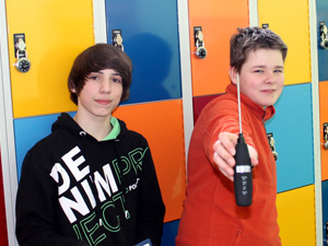 Das Foto zeigt zwei Jungen mit einem Digitalthermometer