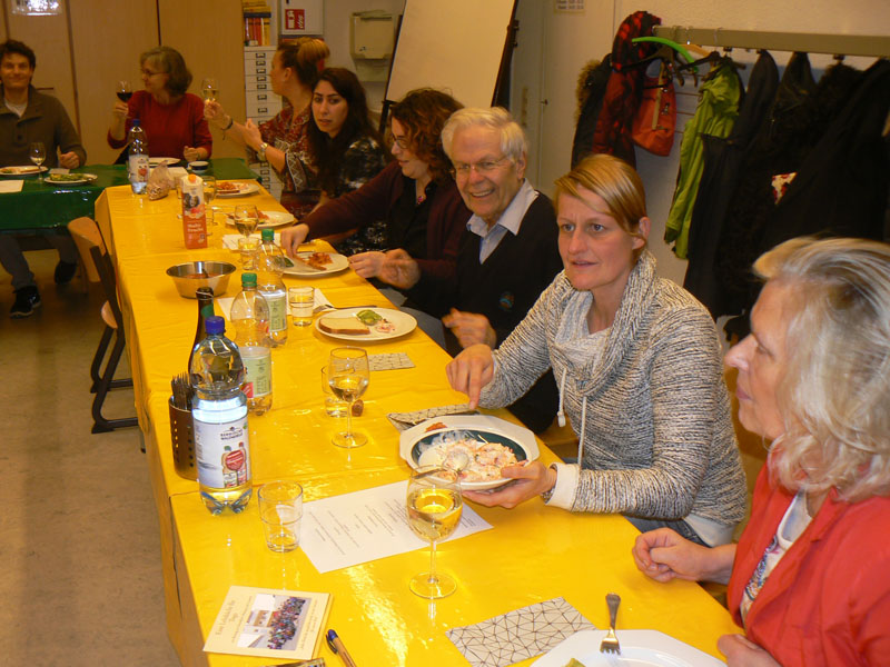 Das Foto zeigt Menschen an einer Festtafel beim Essen.