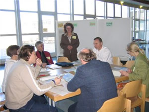 Lehrer sitzen gemeinsam am Tisch und diskutieren über die Arbeiten
