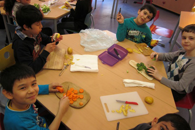 Das Foto zeigt Kinder, die Gemüse zubereiten.
