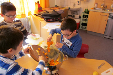Das Foto zeigt Kinder, die Gemüse zubereiten.