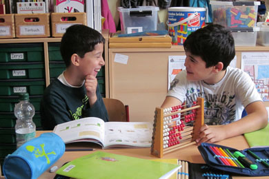 Das Foto zwei Jungen, die gemeinsam Rechnen lernen.