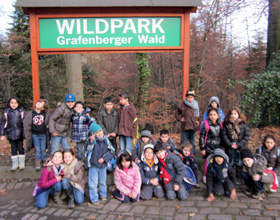 Das Foto zeigt Schulkinder vor dem Eingang des Wildparks Grafenberger Wald.
