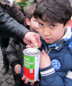 Das Foto zeigt einen Jungen mit einer Spendendose der Welthungerhilfe.