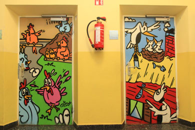 Das Foto zeigt zwei bunt angemalte Türen in einer Schule.