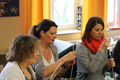 Das Foto zeigt Lehrerinnen bei einer Team-Übung, bei der aus Strohhalmen ein Turm gebaut werden soll.