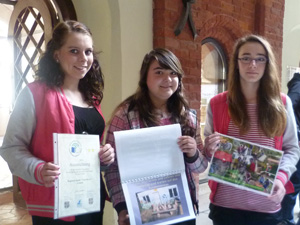 Das Foto zeigt drei Schülerinnen, die einen Umweltpokal gewonnen haben.