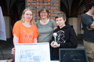 Das Foto zeigt zwei Schüler der Caspar-David-Friedrich-Schule, Greifswald, mit ihrer Betreuerin Janine Eckhardt, die vor dem Stralsunder Rathaus ihr Umweltprojekt vorstellen