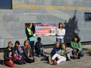 Das Foto zeigt eine Gruppe von SchülerInnen mit einem Klimadetektive-Tragsparent vor der Integrierten Gesamtschule Grünthal in Sralsund.