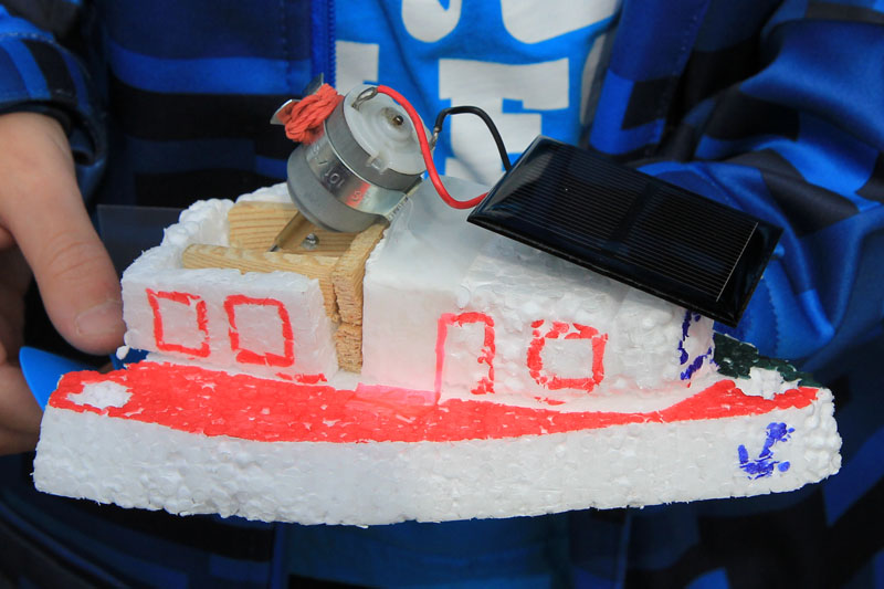 Das Foto zeigt ein Solarboot, also ein kleines Bootsmodell, das mit einem Motor angetrieben wird, der seine Energie von einer Solarzelle bekommt.