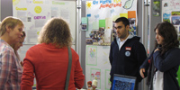Das Foto zeigt zwei Schüler, die mit zwei Lehrerinnen diskutieren, im Hintergrund Poster zu einem Energieprojekt.