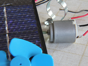 Das Foto zeigt einen Solarbausatz,bestehend aus: einer Solarzelle, einem Elektromotor mit Befestigungsschelle und einem Propeller.