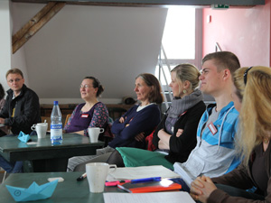 Das Foto zeigt aufmerksame Teilnehmer eines Seminars, an Tischen sitzend.