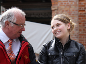 Das Foto zeigt zwei Menschen bei der Übergabe eines Preises vor dem Stralsunder Rathaus.