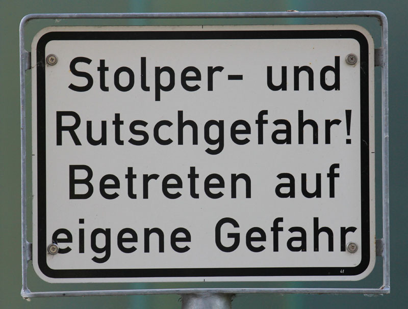 Das Foto zeigt ein Schild mit der Aufschrift: Stolper- und Rutschgefahr! Betreten auf eigene Gefahr!