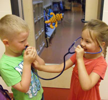 Das Bild zeigt zwei Kinder mit einem Stethoskop